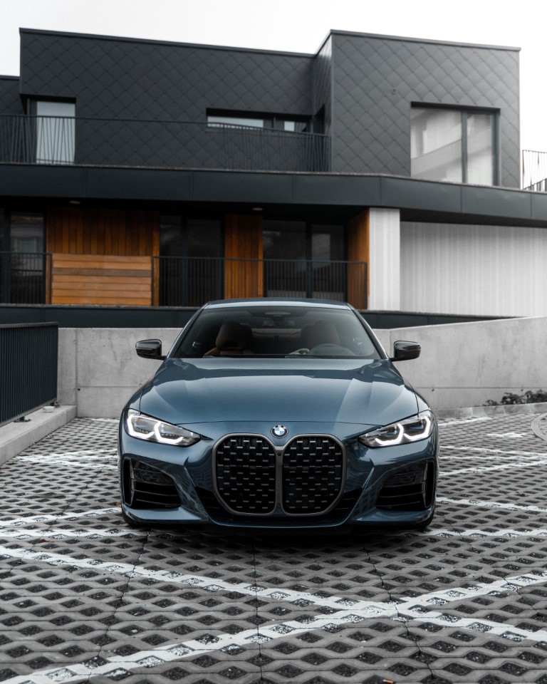 BMW parked in front of a modern house