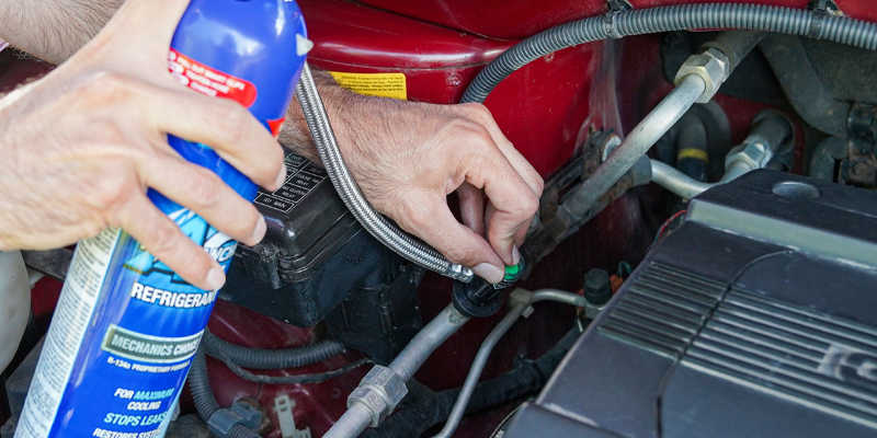 inserting can of refrigerant into the car