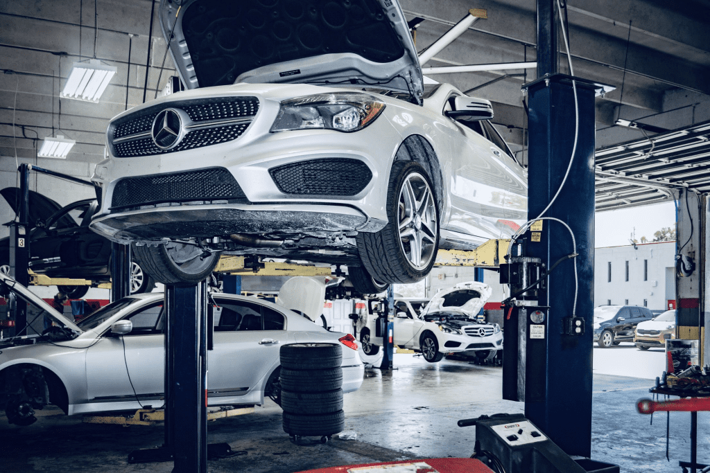 a Mercedes up on a lift in a garage 