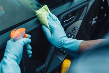 Someone cleaning of the car's interior using a DIY cleaner