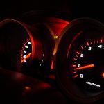 odometer lit up with orange lights at night