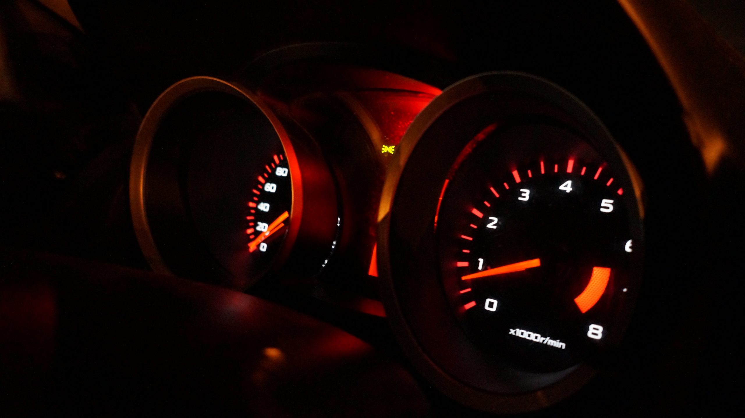 odometer lit up with orange lights at night