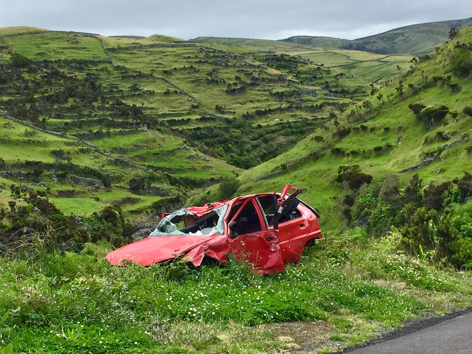 red car broken down on the side of a road
