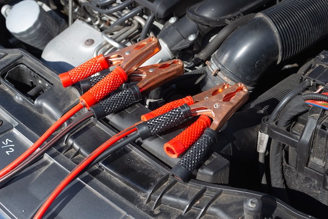 a battery connected to jumper cables