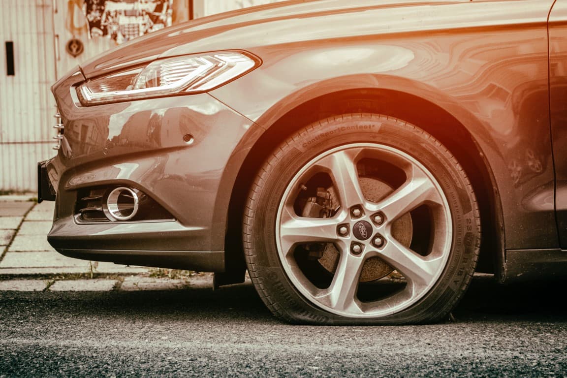 car parked with a tire that has gone flat
