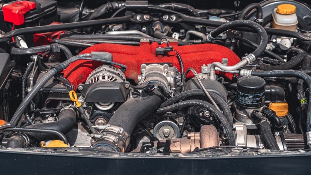 a large car engine exposed with belts and lines exposed