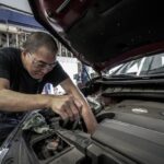 a mechanic checking in on a cars fluids