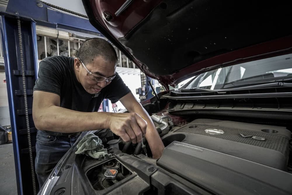 a mechanic checking in on a cars fluids
