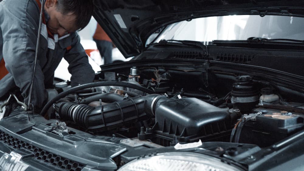 mechanic looking at a cars engine