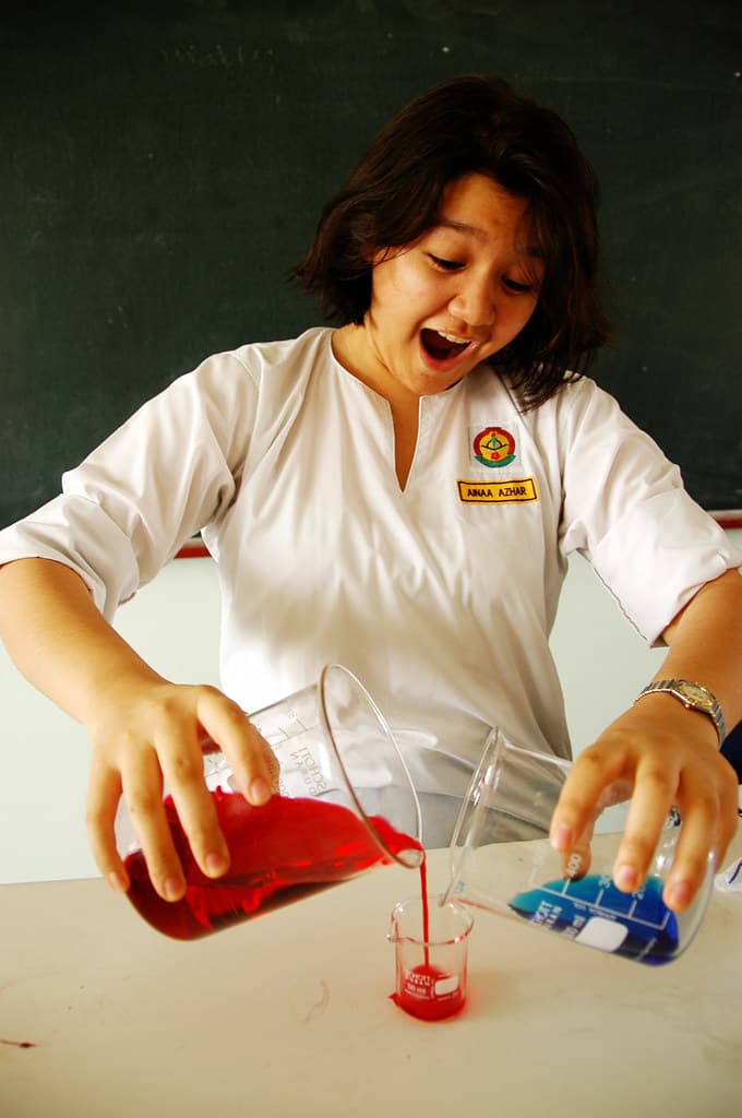 person mixing a blue and red liquid