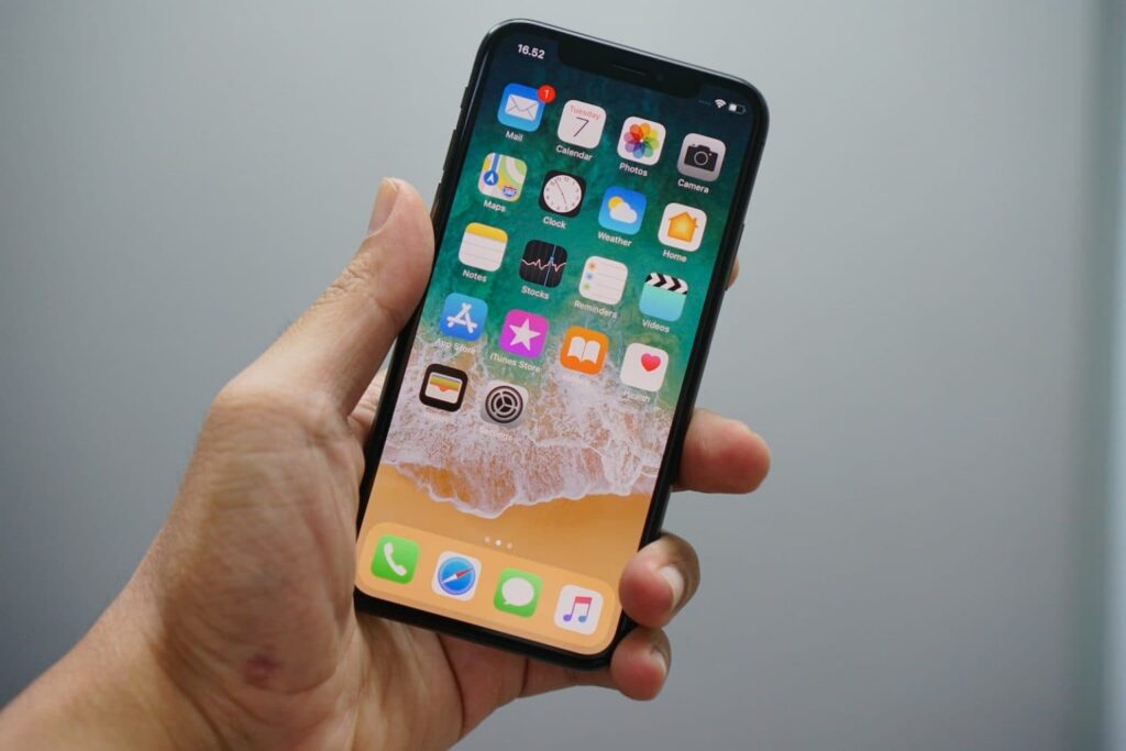 person holding space gray iPhone 7 to connect to bluedriver