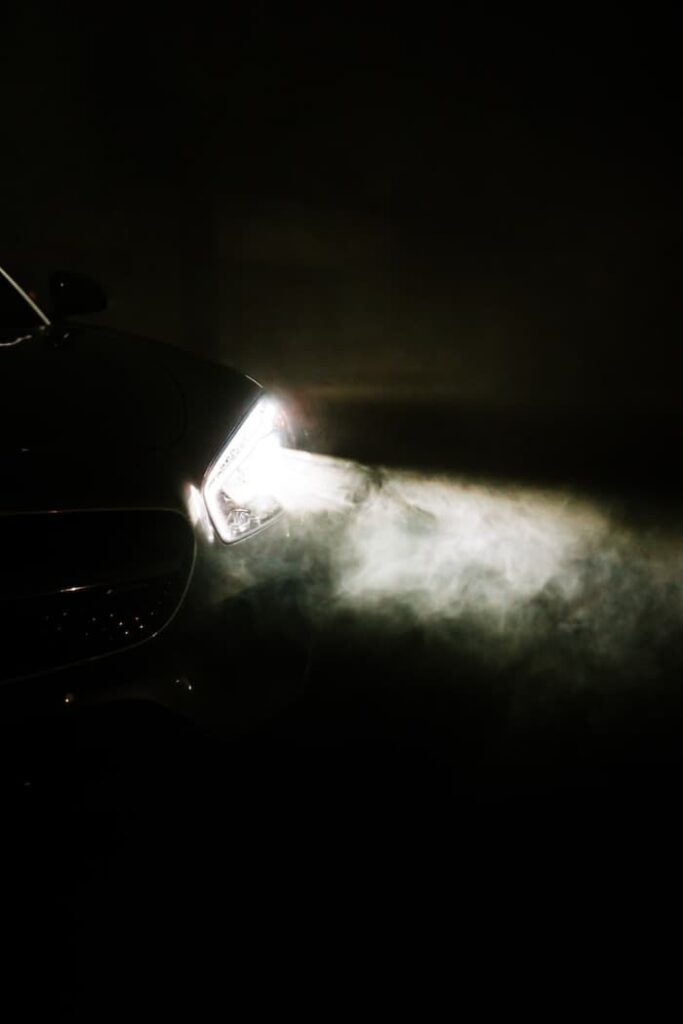 black car with white smoke in lights
