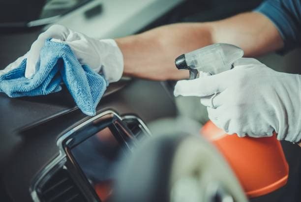 Spraying DIY Car Cleaning Solution in the dashboard