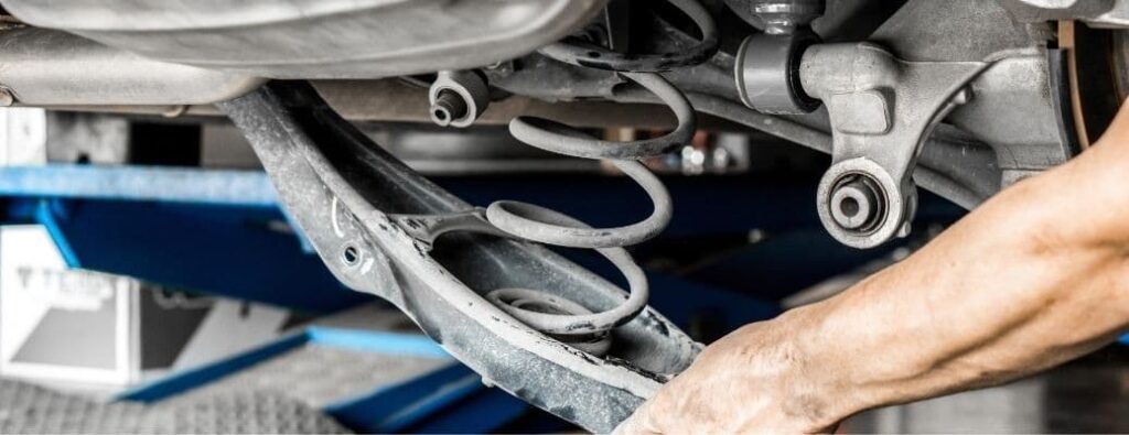 someone is checking the suspension of the car for safety purposes