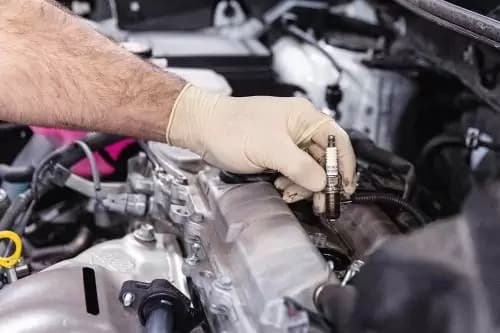 someone fixing the spark plug in the car engine
