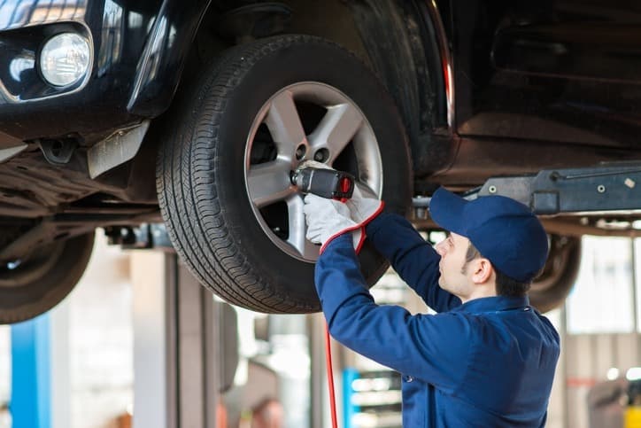 Checking the tires of the car and rotating it as needed by a mechanic