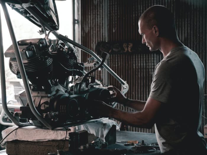 mechanic holding engine above a bay