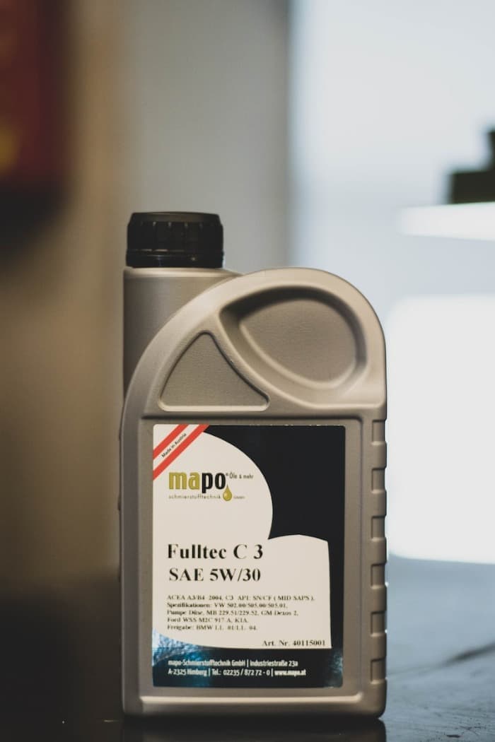 black and white plastic bottle filled with motor oil