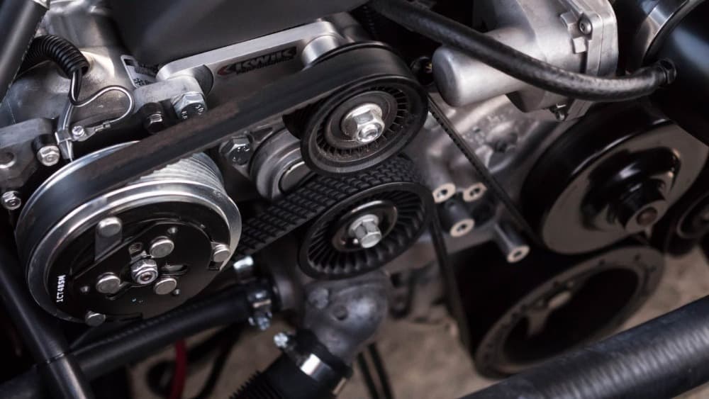a car engine exposed with the belts showing